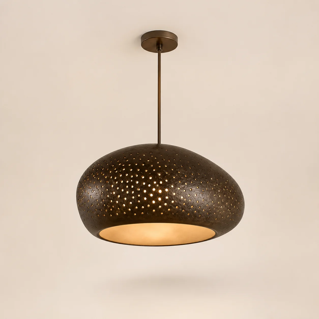Noor Perforated Pendant studio concept visual in aged bronze, warm opal