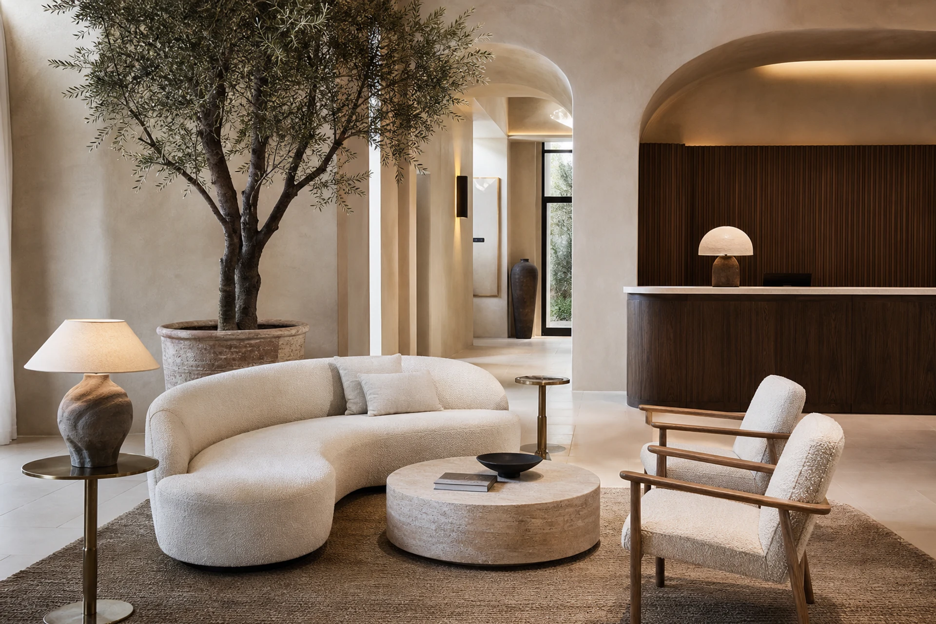 Contemporary Mediterranean hotel lobby with curved sofa, swivel chairs and olive tree