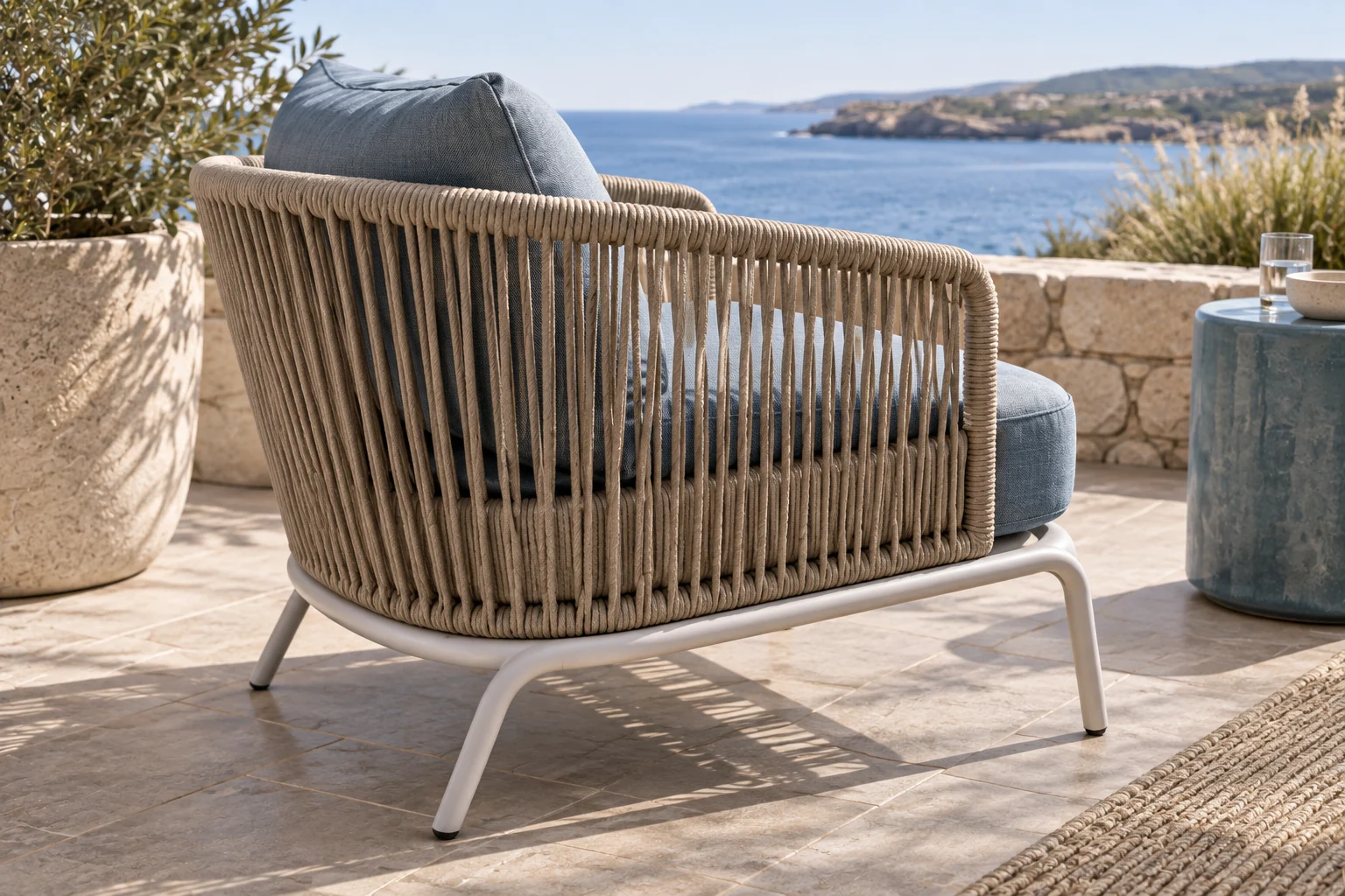 Close detail of oat rope chair back on a curved pale frame with blue seat cushion