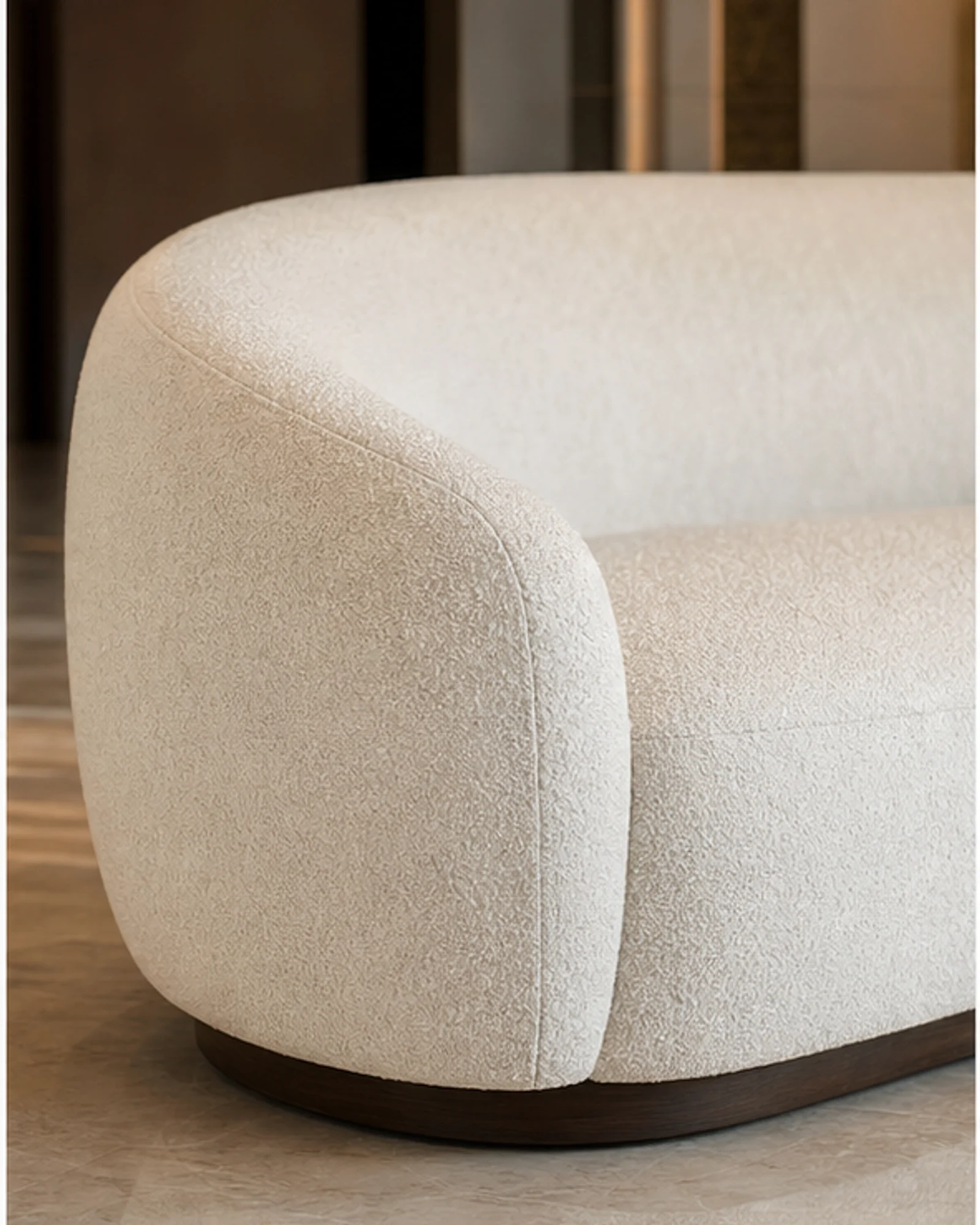 Curved Lobby Sofa detail view - Curved ivory boucle lobby sofa with sculptural silhouette in a luxury hotel lounge