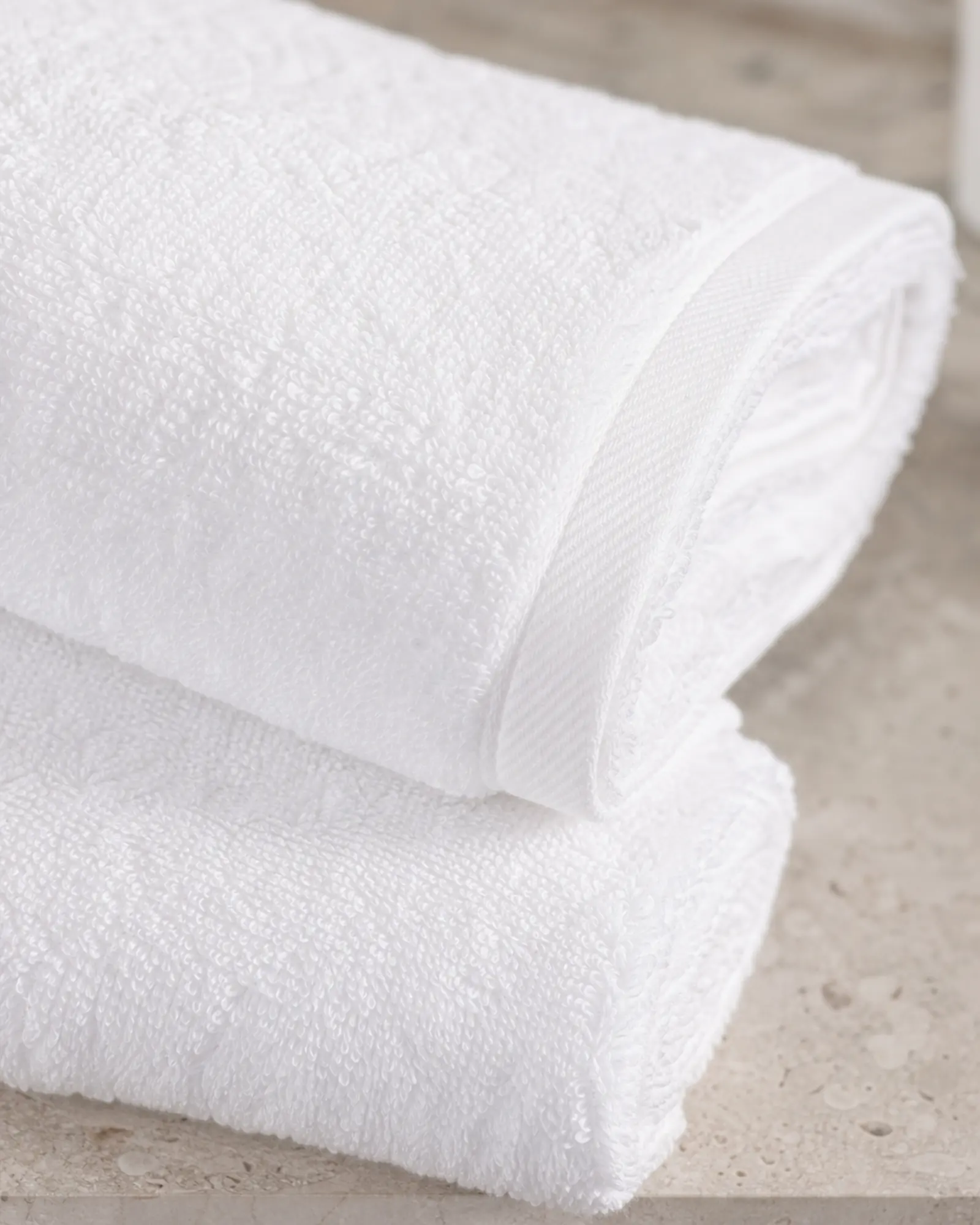 Bath Towel profile - Thick white hotel bath towels stacked in a luxury bathroom